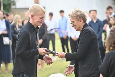 Wręczenie książki uczniowi przez przedstawicielkę zarządu Cechu Rzemiosł Różnych pani Violettę Gzik-Janiak