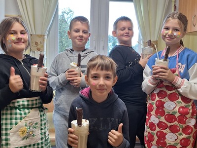 Uśmiechnięte dzieci trzymające w rękach szklanki z deserem