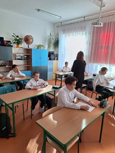 Nauczyciel rozdaje uczniom kartki