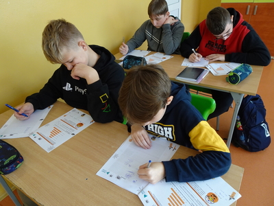 Uczniowie rozwiązują zadania egzaminacyjne o tematyce Halloween