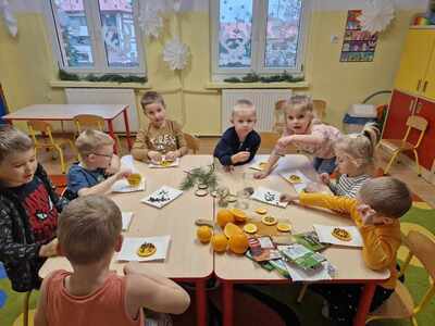 Przedszkolaki poznają zapachy Świąt i ozdabiają pomarańcze goździkami
