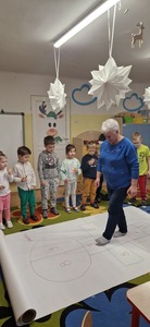 Pani Wiesia pokazuje przedszkolakom jak się gra w ,,Chłopka".