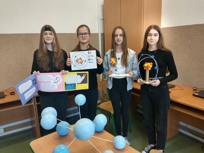 Uczennice z modelami  i plakatami atomów