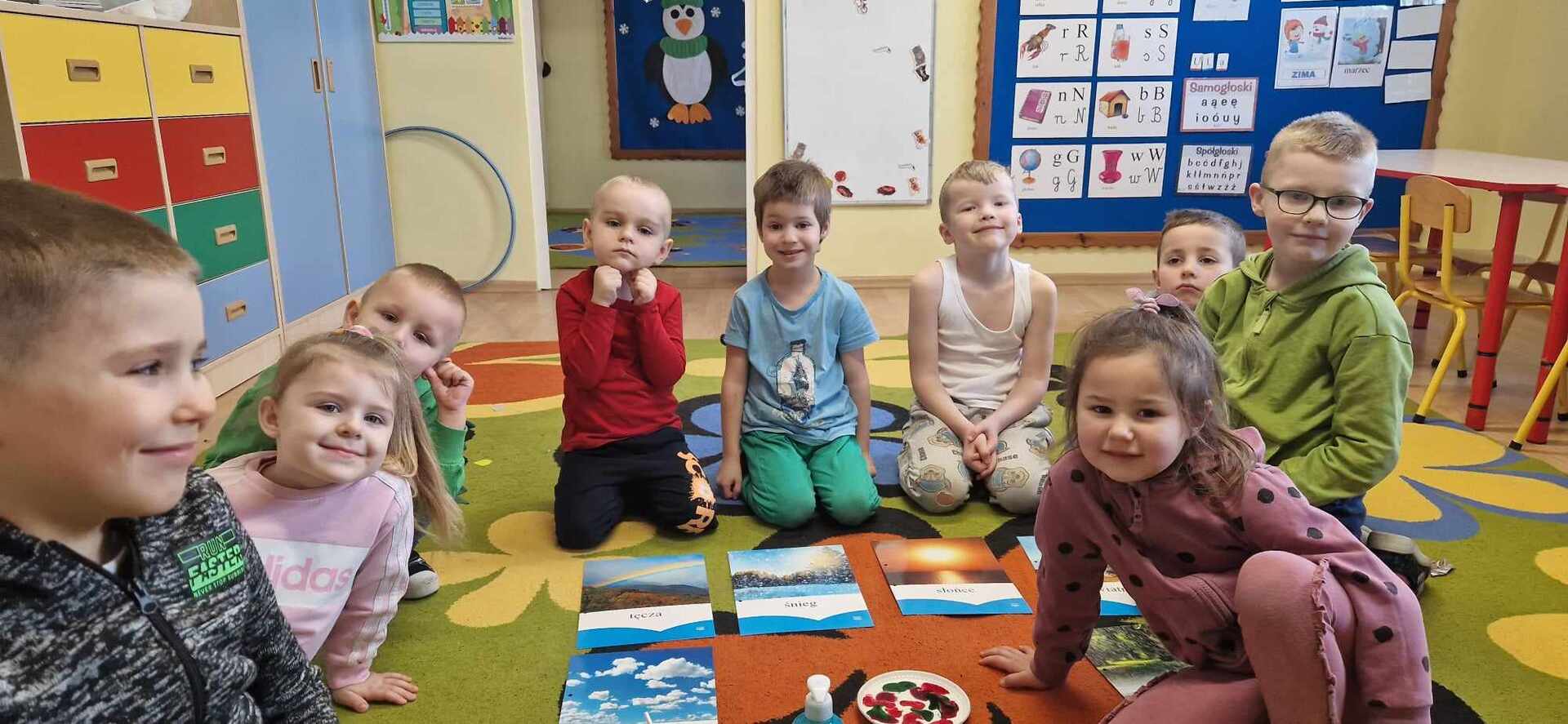 Przedszkolaki wykonują doświadczenie ,,malowanie na mleku"