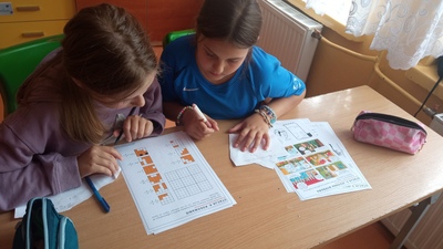 Uczennice klasy V podczas rozwiązywania zagadek matematycznych