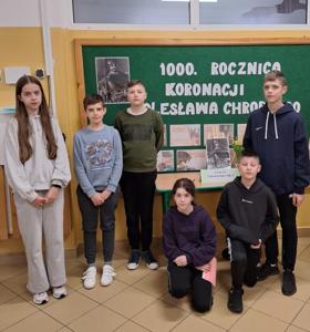 Dzieci na tle gazetki poświęconej koronacji Bolesława Chrobrego