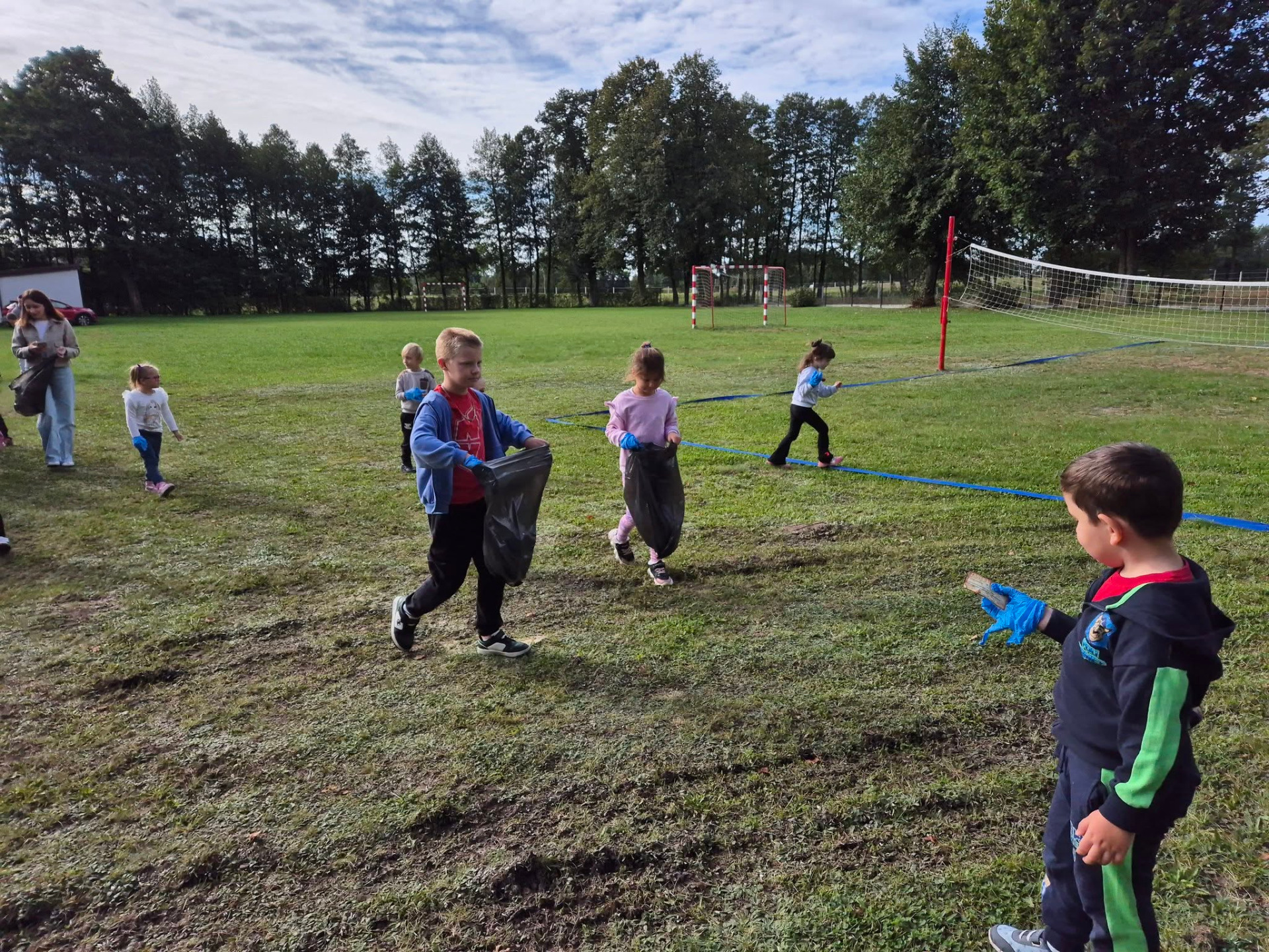 Najmłodsi czniowie sprzątają boisko szkolne
