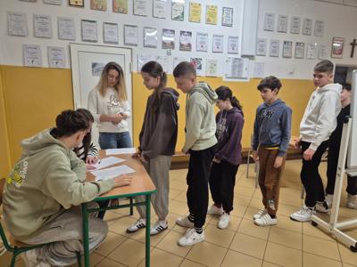 Uczniowie podpisują odebranie kart do głosowania