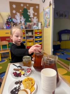  Dziewczynka przygotowuje zimową herbatkę.