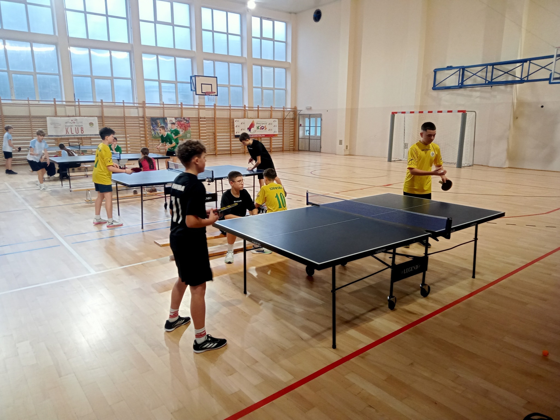 Uczniowie w trakcie meczu przy stołach.