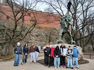 Uczniowie przed posągiem smoka wawelskiego.