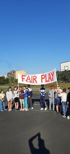 Dzieci trzymają transparent z napisem FAIR Play