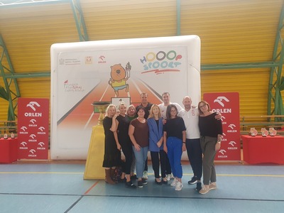 Grupa nauczycieli stoi razem z olimpijczykami