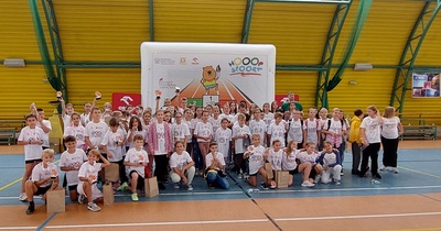 Uczniowie stoją razem z olimpijczykami