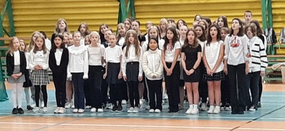 Uczniowie klas starszych z chóru szkolnego śpiewający piosenkę.