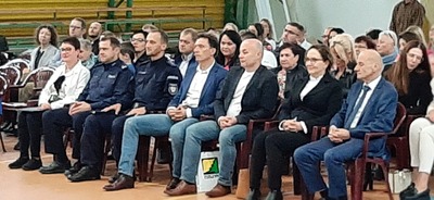 Zaproszeni goście wraz z panią dyrektor siedzą podczas ślubowania.