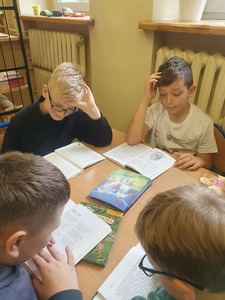 Chłopcy czytają książki w bibliotece