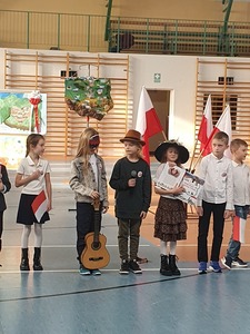 Grupa dzieci, w tle mapa Polski i flagi 