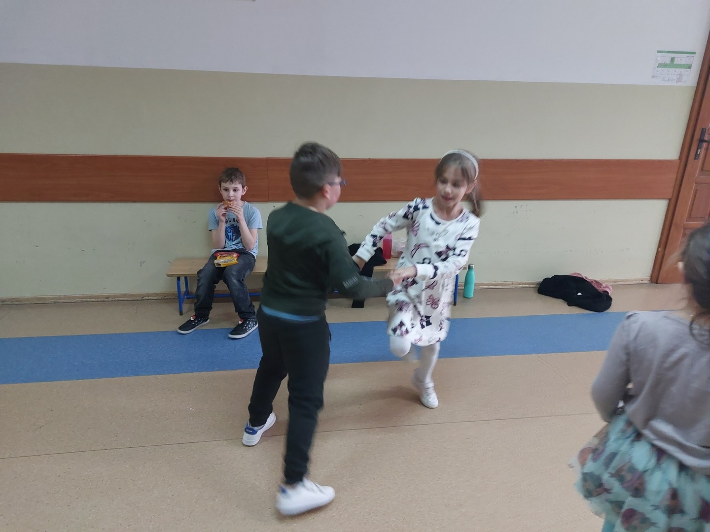 Chłopiec i dziewczynka tańczą trzymając się za ręce