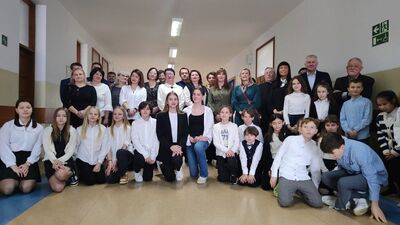 Grupa  osób stojąca na korytarzu szkolnym, w tym między innymi Dyrekcja SP Nr1 w Tuszynie, Wiceprzewodnicząca  Rady Powiatu Łódzkiego Wschodniego, Przedstawiciele Władz Gminy, Radni, Dyrektorzy i Kierownicy jednostek organizacyjnych, Ks. Proboszcz z parafii w Tuszynie oraz Nauczyciele i Uczniowie SP Nr 1 w Tuszynie