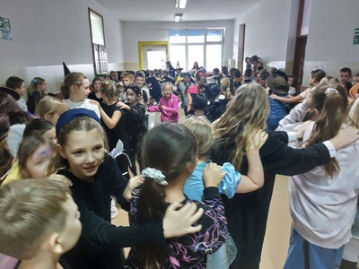 Korytarz szkolny - uczniowie tańczą tworząc pociąg