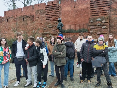 Uczniowie stoją przed Pomnikiem Małego Powstańca 