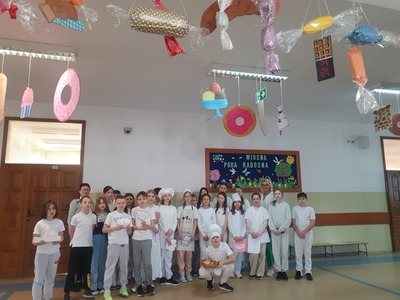 Uczniowie w strojach piekarzy i cukierników wraz z wychowawczynią i panią dyrektor