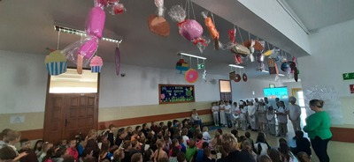 Uczniowie na tle dekoracji okolicznościowej.
