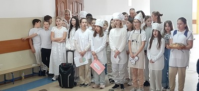 Uczniowie w strojach piekarzy śpiewają piosenkę