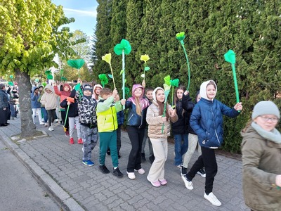 Uczniowie maszerują ulicami Tuszyna z okazji Dnia Ziemi.
