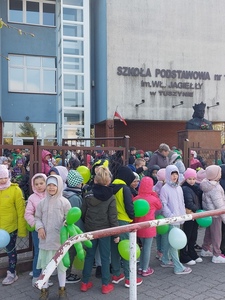 Uczniowie przed budynkiem szkoły w oczekiwaniu na marsz z okazji Dnia Ziemi.