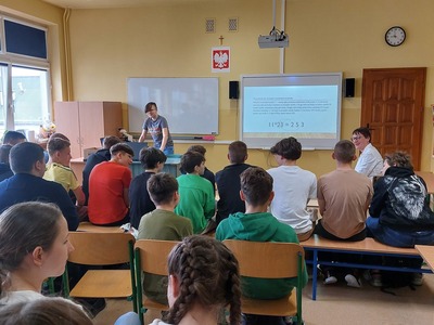 Grupa uczniów wraz z Panią Dyrektor szkoły ogląda prezentację multimedialną.