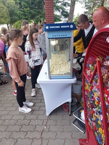 Grupa uczniów stojąca przed automatem na popcorn.
