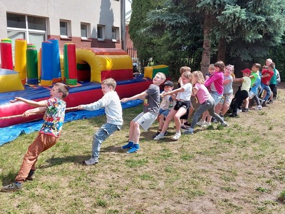 Grupa uczniów ciągnąca linę.