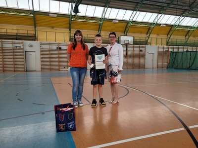 Hala sportowa. Grupa uczniów z klasy 4b stoi w szeregu, trzymając dyplomy. Obok nich stoi nauczyciel i dyrekcja szkoły.
