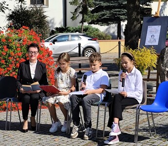 Dyrektor wraz z uczniami siedzą na krzesłach  czytający fragmenty "Kordiana" J. Słowackiego