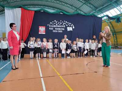Pani Dyrektor w otoczeniu uczniów słuchająca przemówienia zaproszonego gościa. 