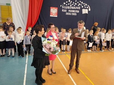 Pani Dyrektor w otoczeniu uczniów słuchająca przemówienia zaproszonego gościa. 