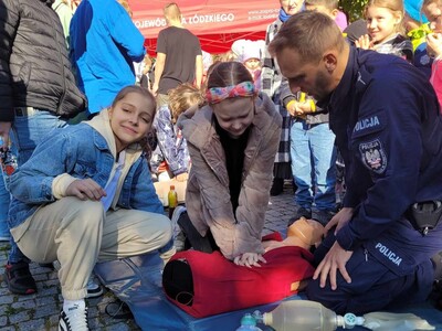 Uczennice pod nadzorem strażaka z OSP w Tuszynie wykonująca masaż serca na fantomie.