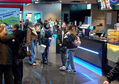 Uczniowie czekający na seans filmowy w holu kina Helios.