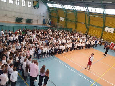 Uczniowie na hali gimnastycznej odśpiewujący  Hymn Polski