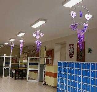 Hol szkolny przyozdobiony fioletowymi sercami.