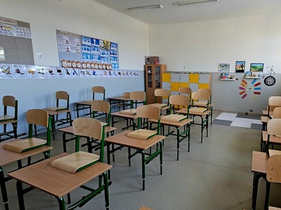 klasa lekcyjna,  w rzędzie ustawione ławki, na ścianach tablice