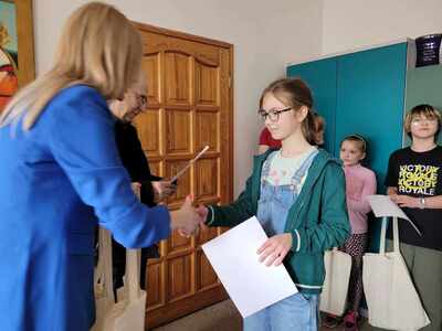 kobieta wręczająca dyplom uczennicy.