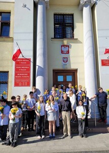 Uczniowie przed gmachem urzędu miasta w raz z nauczycielem i zaproszonego gościa.