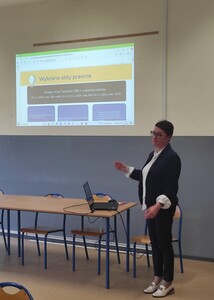 Pani dyrektor występująca przed zgromadzonymi w pomieszczeniu.