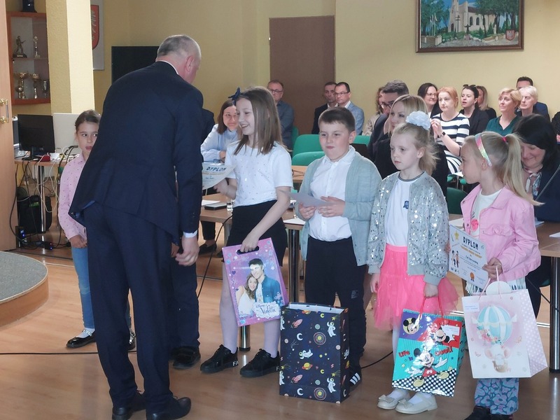 Przedstawiciel Rady Miasta wręcza nagrody laureatom w sali konferencyjnej w Urzędzie Miasta Tuszyna.