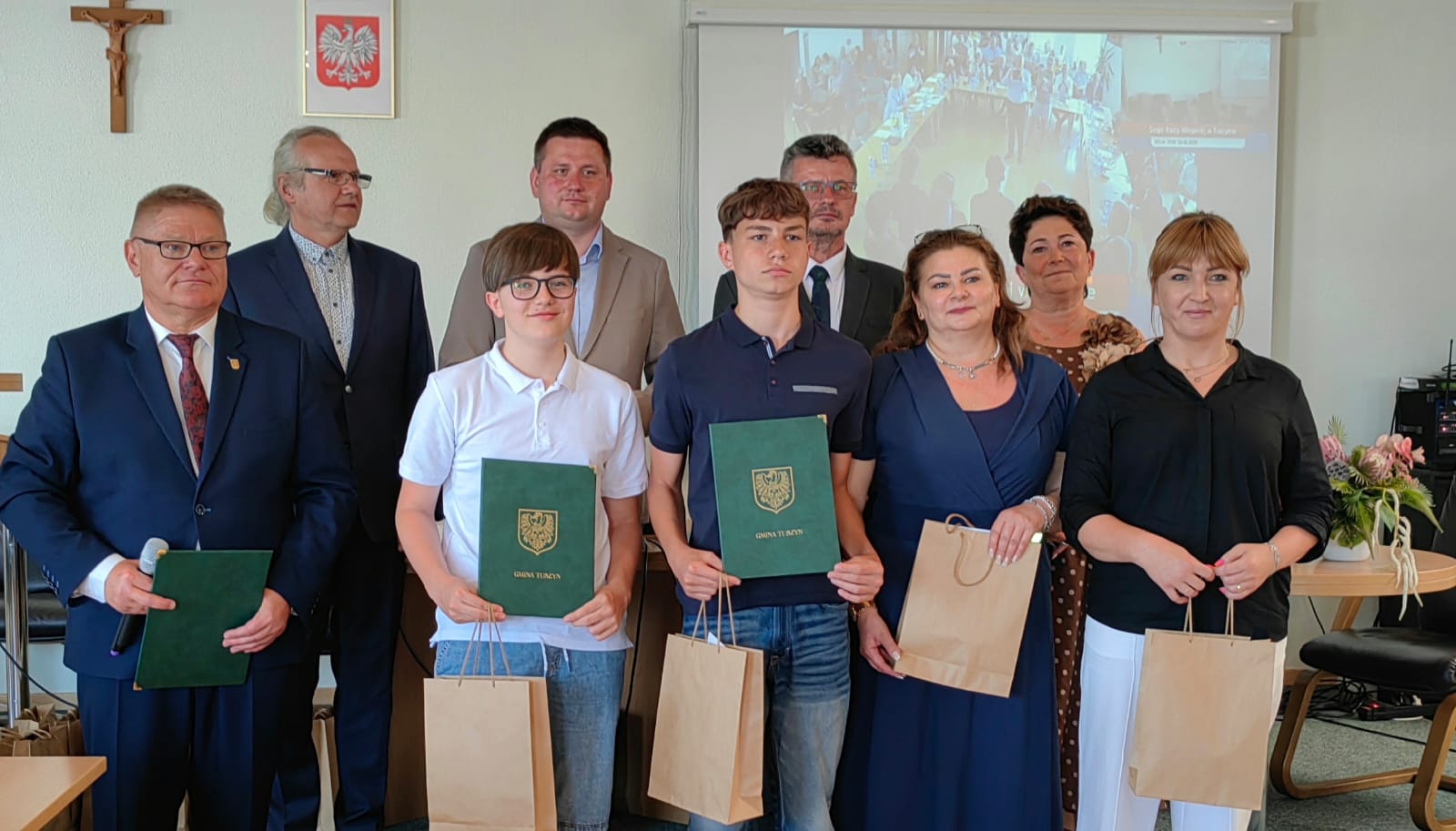 Uczniowie prezentujący dyplomy w towarzystwie nauczycieli oraz z Burmistrzem Miasta Tuszyn i innych przedstawicieli władz.