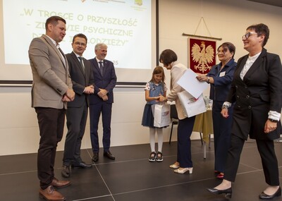 Dani Dyrektor na podium odbierająca nagrodę dla ucznia.