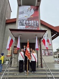 Uczniowie ze Sztandarem szkoły przed Kościołem Św. Krzysztofa w Tuszyn Lesie.